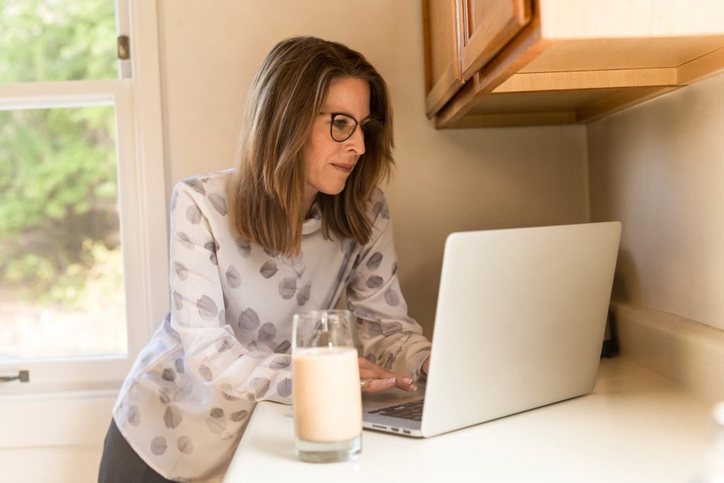 woman working on laptop at kitchen counter